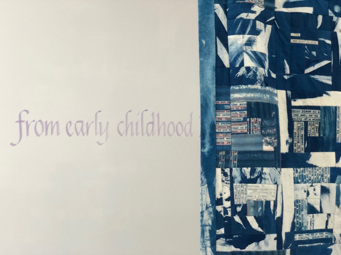 Close up on Law Quilt's edge, text on the wall reading "from early childhood" showing on the wall behind. 